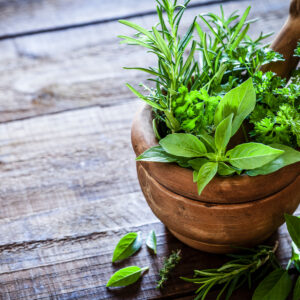 Image of herbs in a wooden bowl.