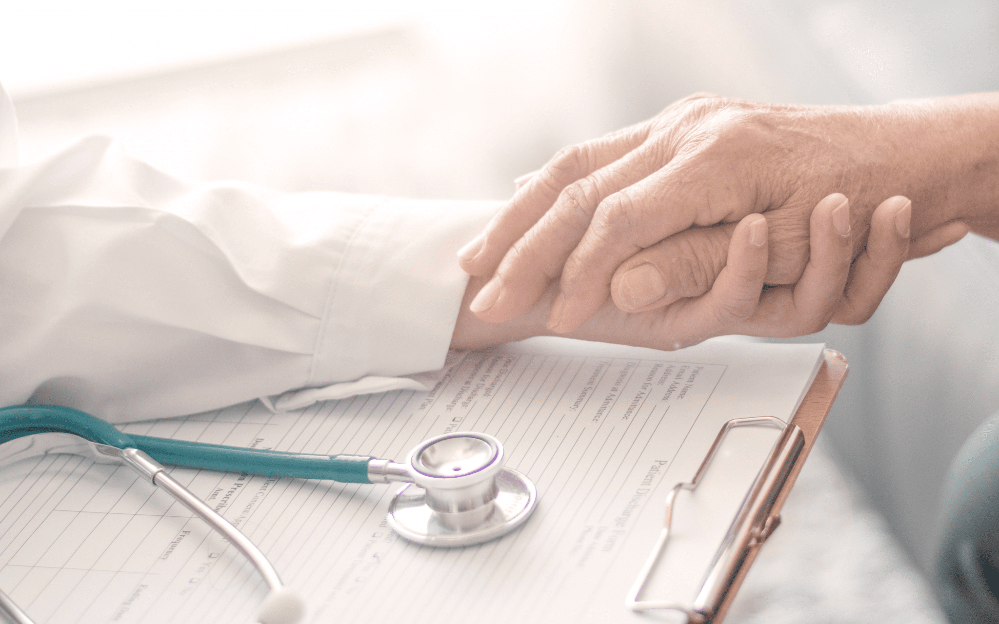 mesothelioma doctor holding their elderly patient's hand.