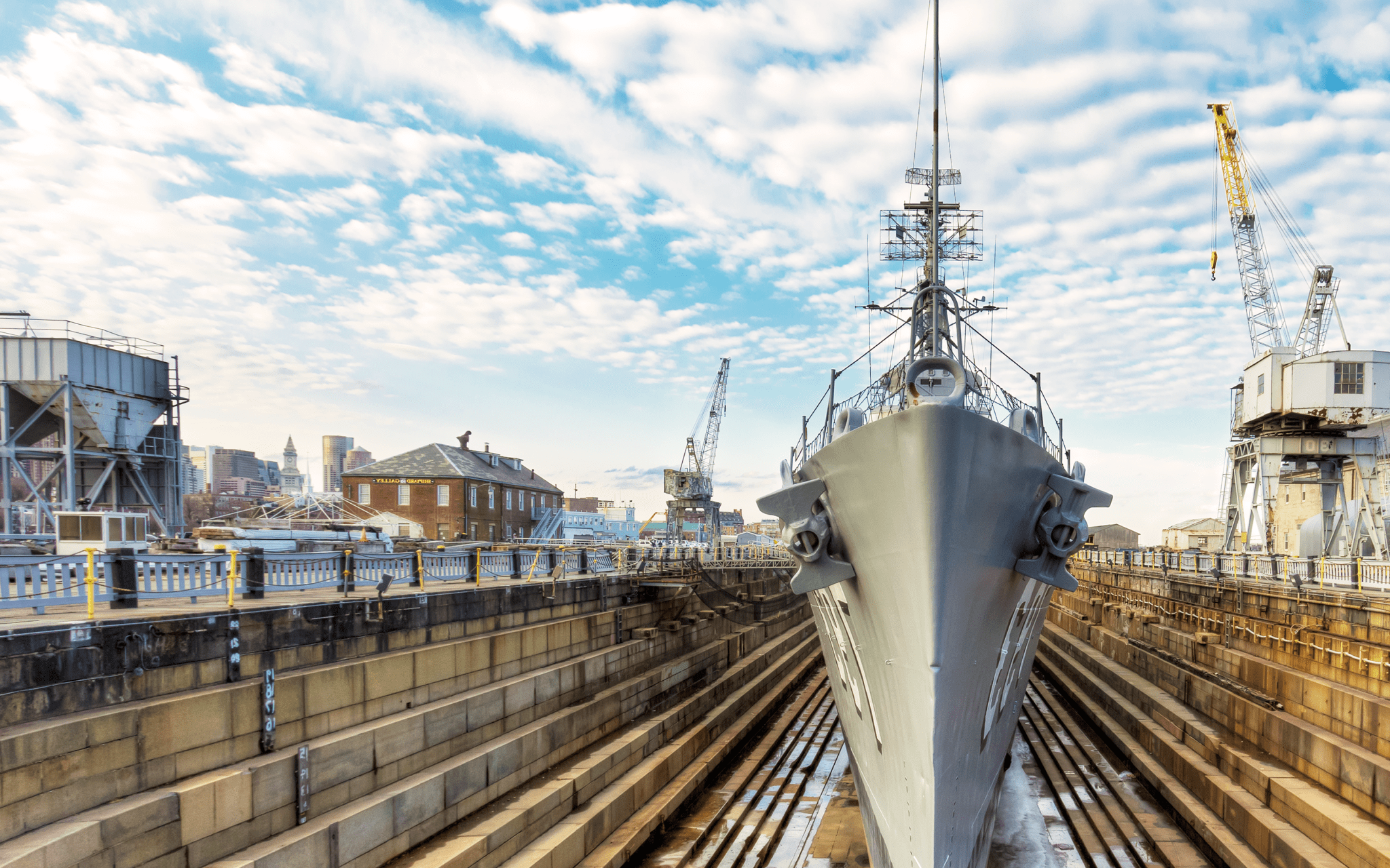 Naval ship sits in a boatyard.