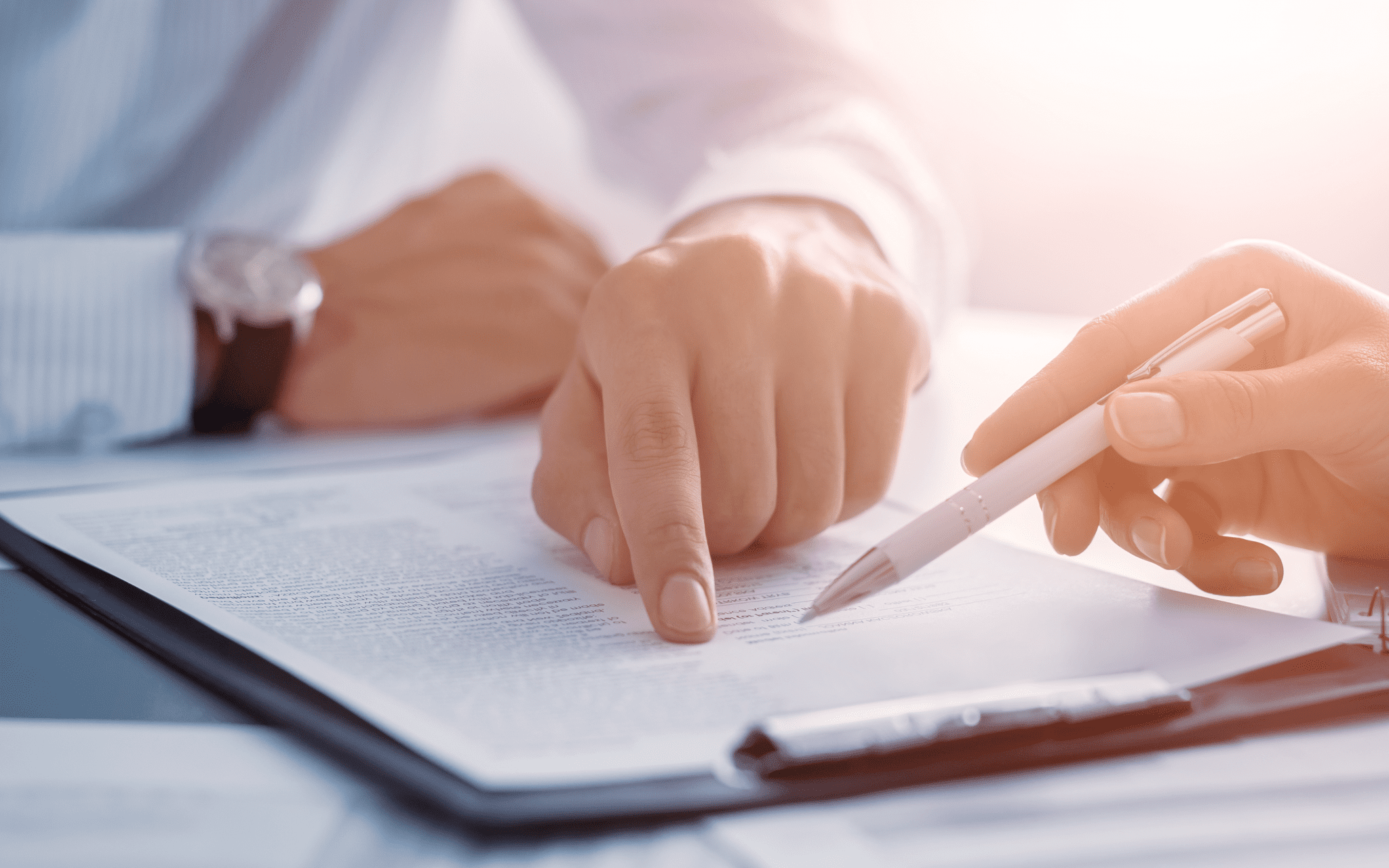 Closeup of hands pointing to a mesothelioma class action lawsuit on a clipboard.