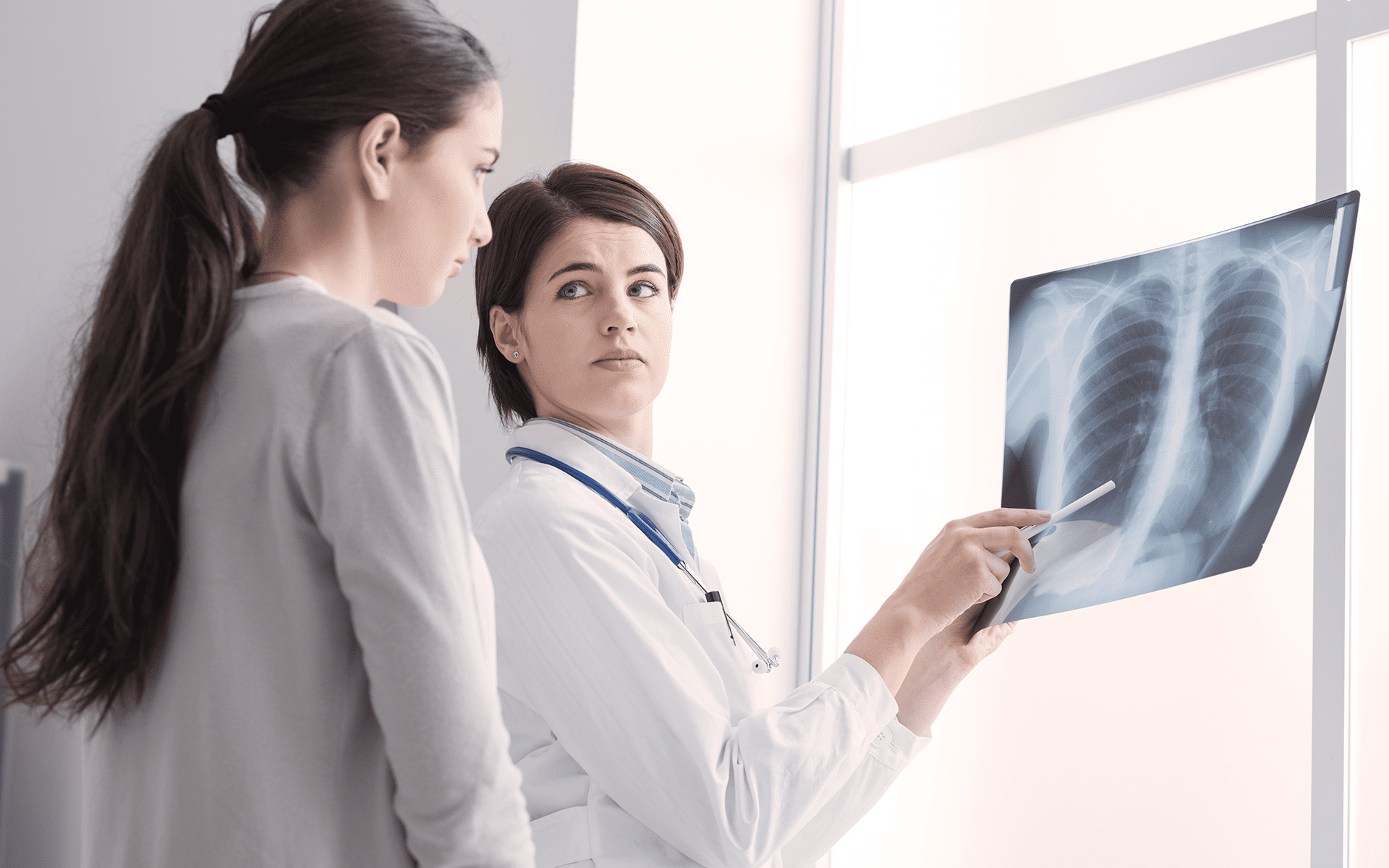 mesothelioma doctor shows patient her x-rays.