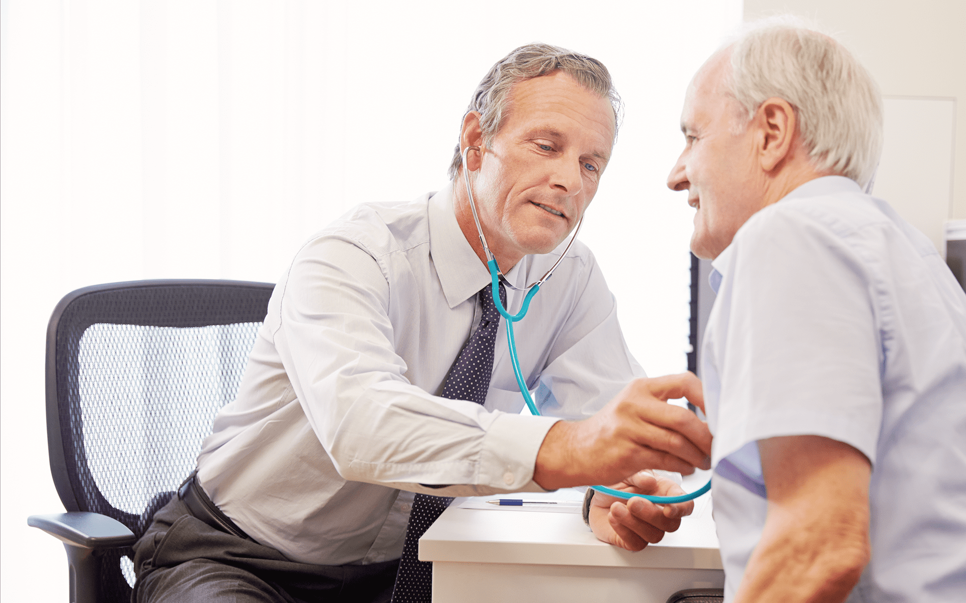 mesothelioma doctor checks on patients heart beat with stethoscope.