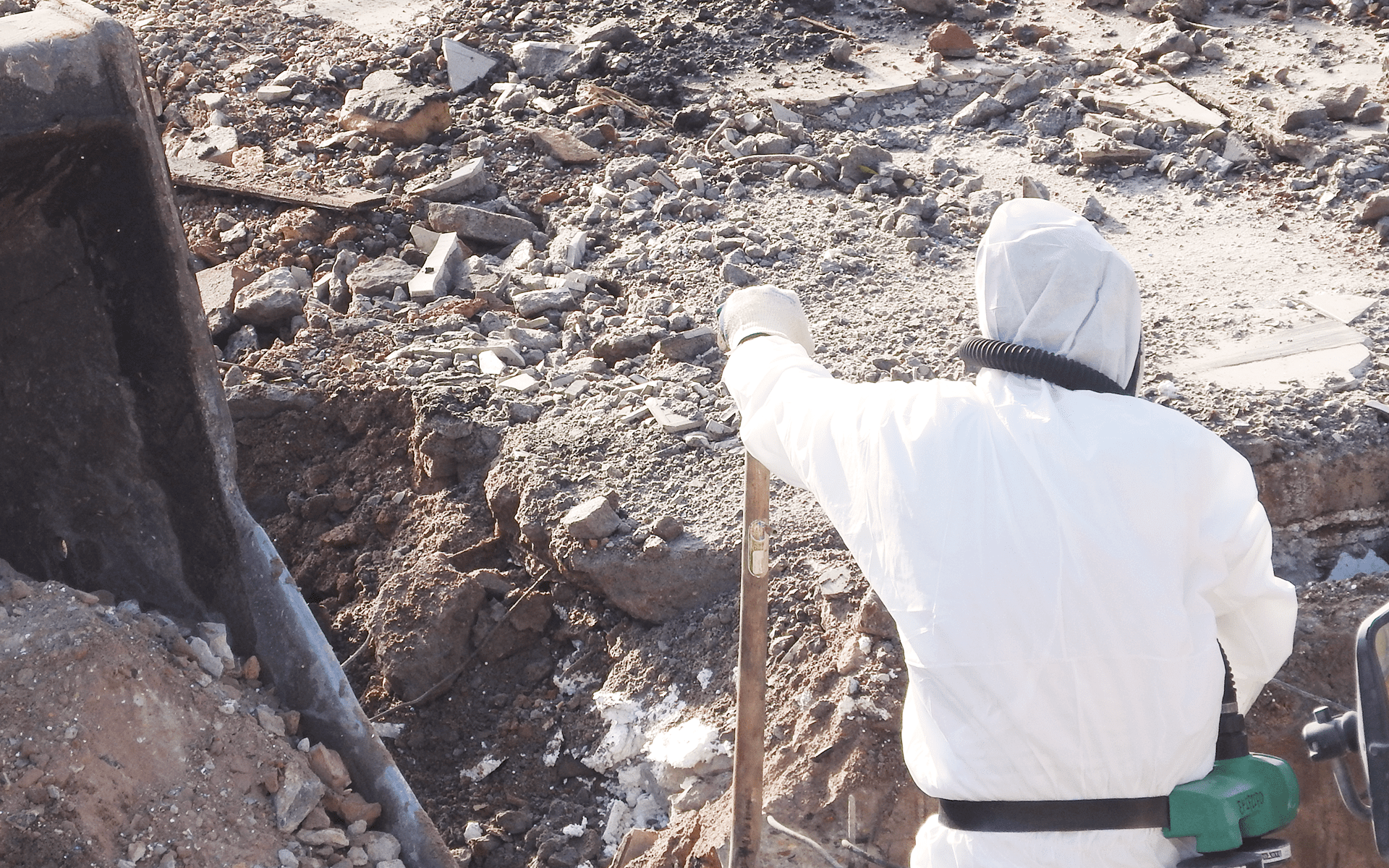 Worker in PPE gear taking a rest while evacuating a hole.