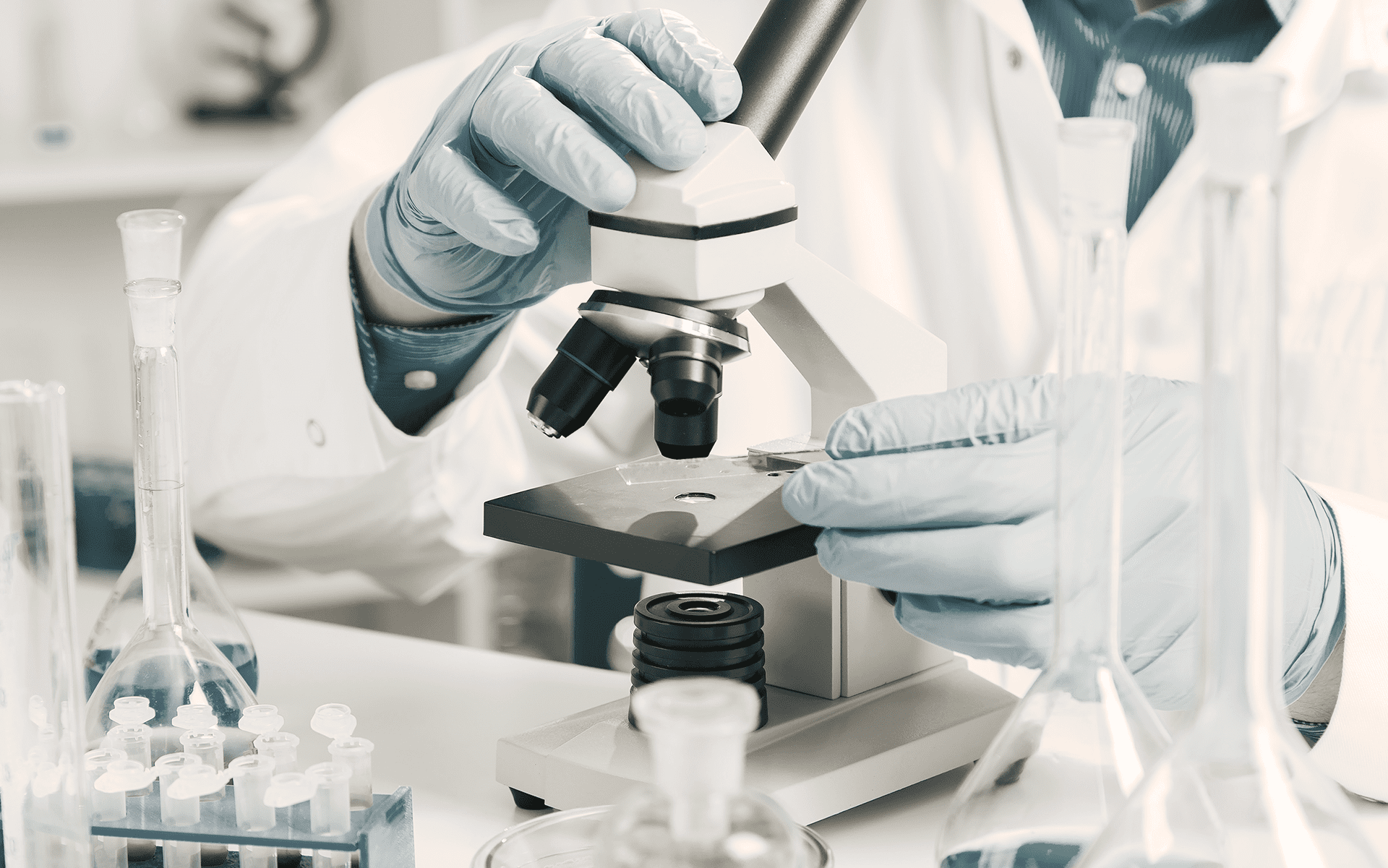 A doctor studying a sample under a microscope from a biopsy.