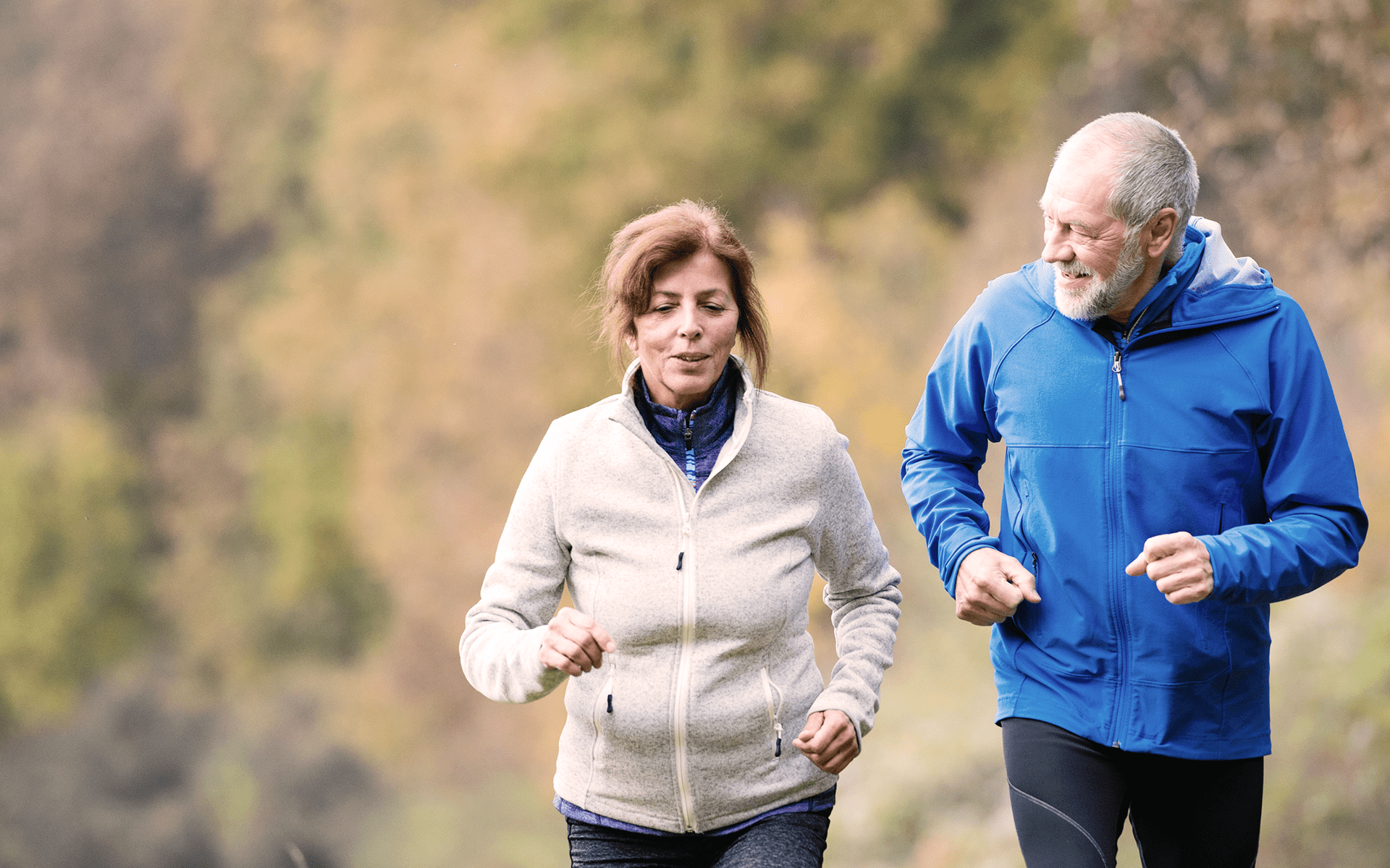 A couple jogs on a fall day.