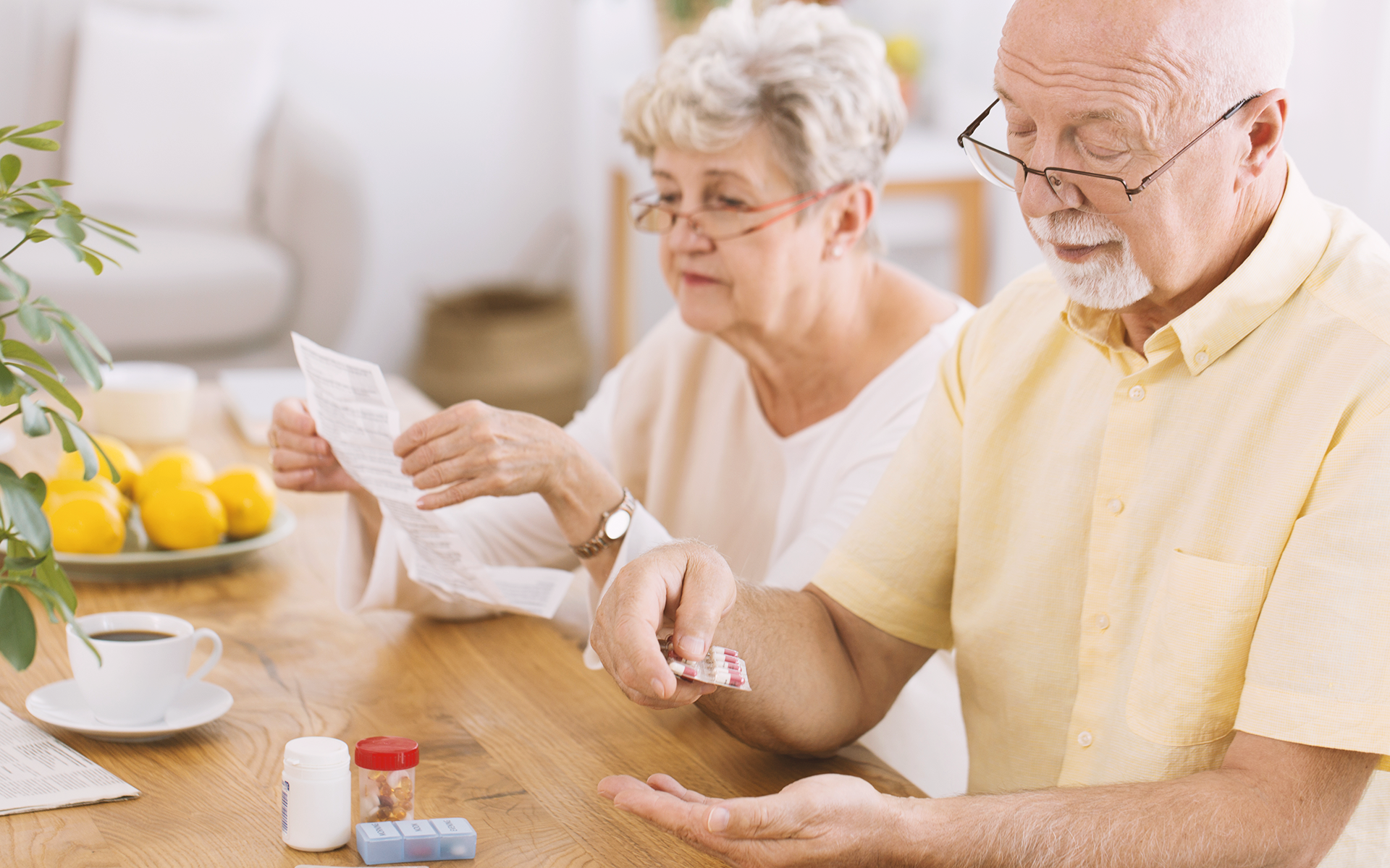 An elderly couple sorting through medications.