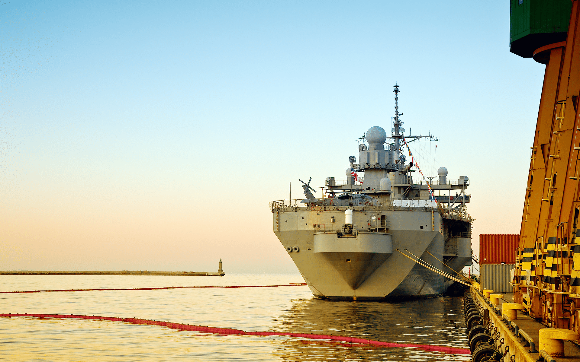 A Navy ship on the water in a harbor.