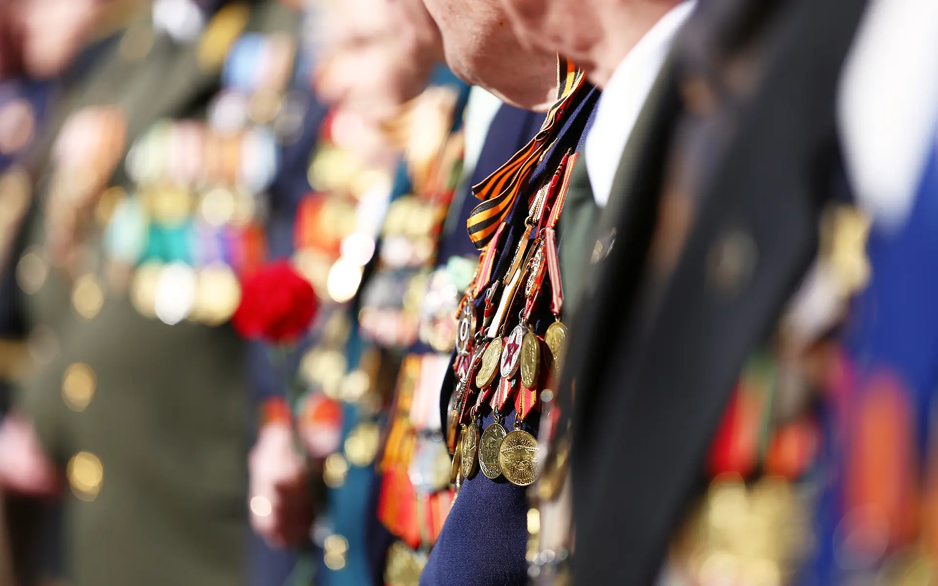 Closeup of military medals on the neck of a veteran at an award ceremony.