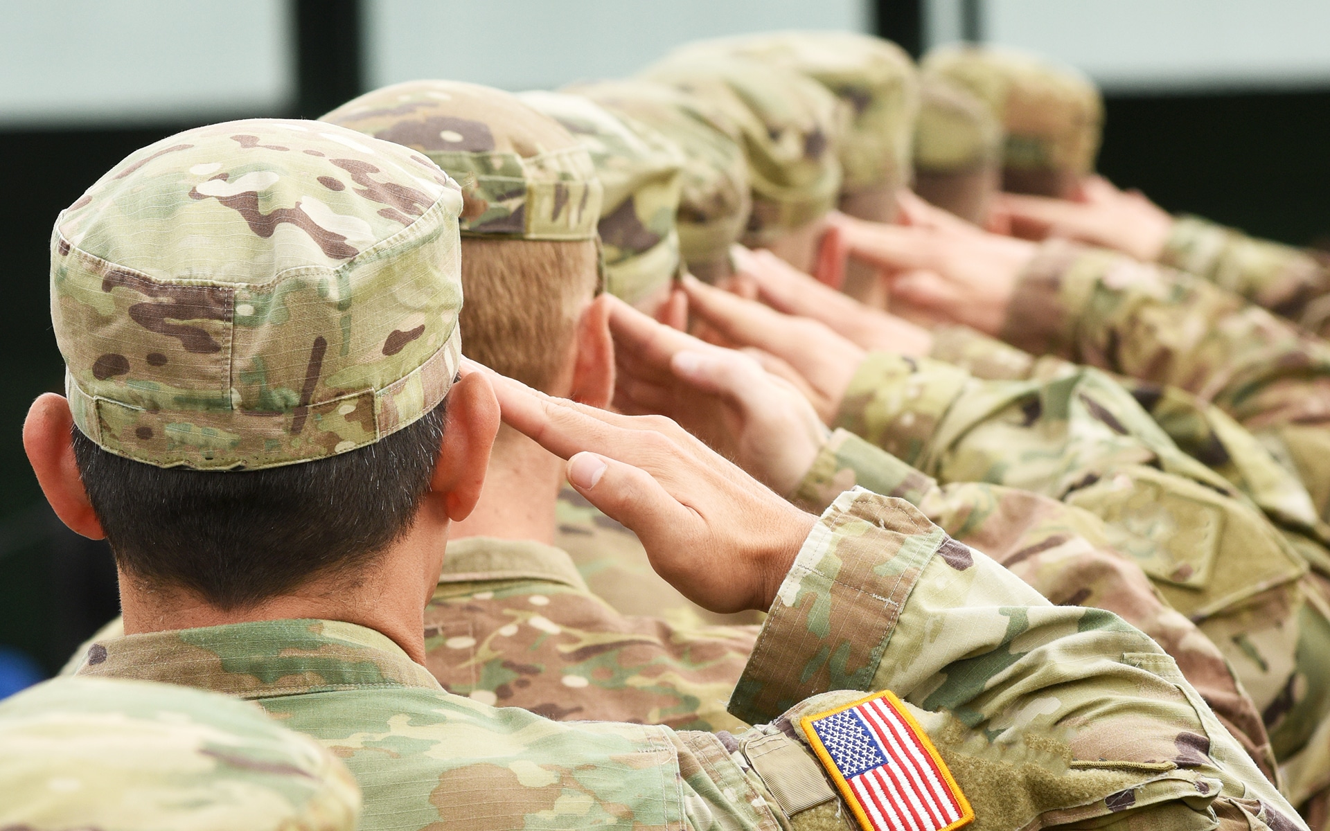 A line of veterans saluting forward in a straight line.