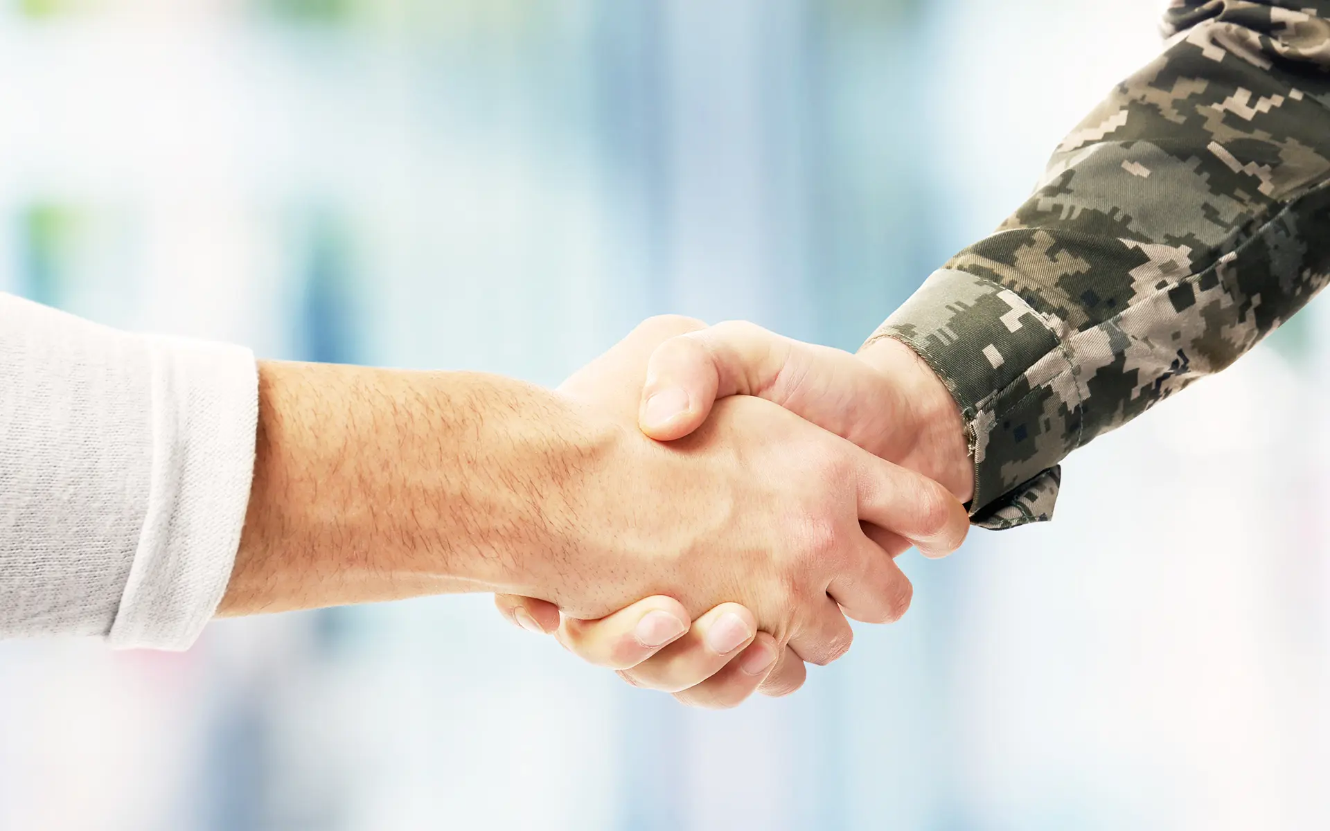 Closeup of two shaking hands, one belonging to a Veteran.