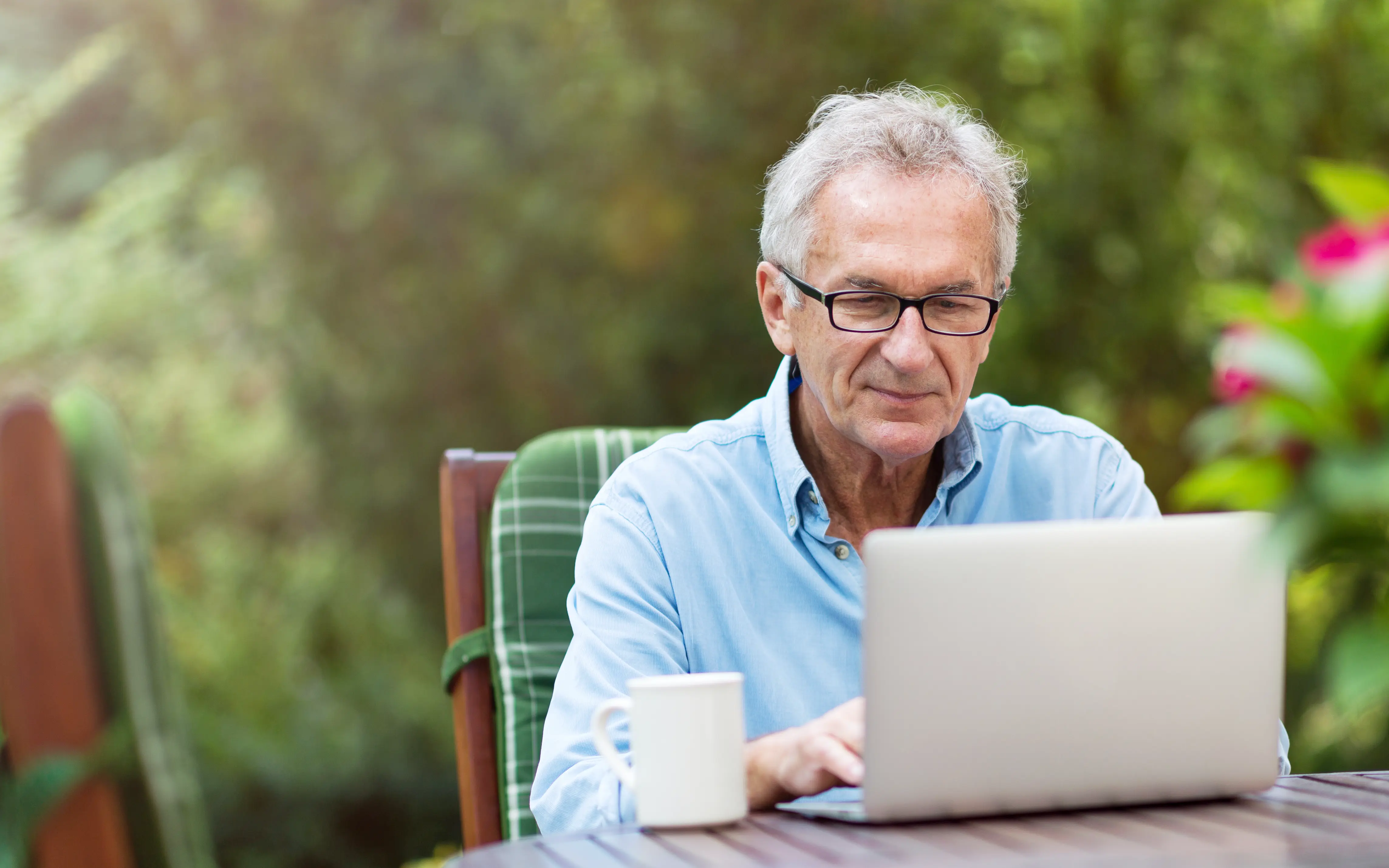 An elderly gentleman looking into eBenefits for Veterans on his laptop.