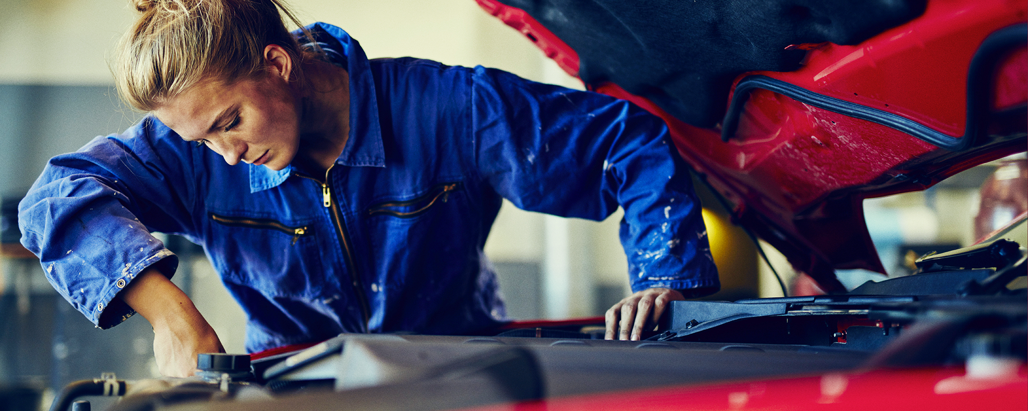 A mechanic working on a vehicle with the potential risk of asbestos exosure.