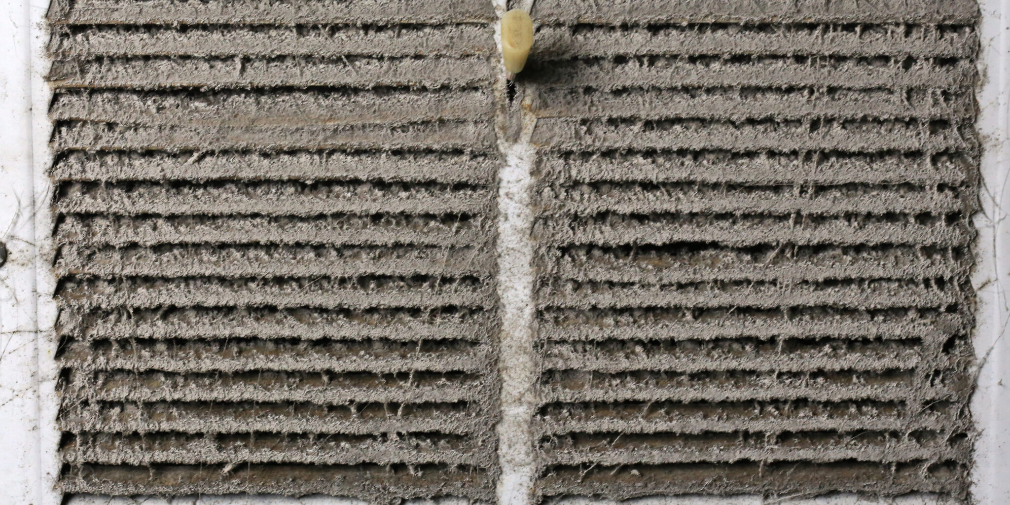 old dusty vac air vent with lots of dust and debris on panels