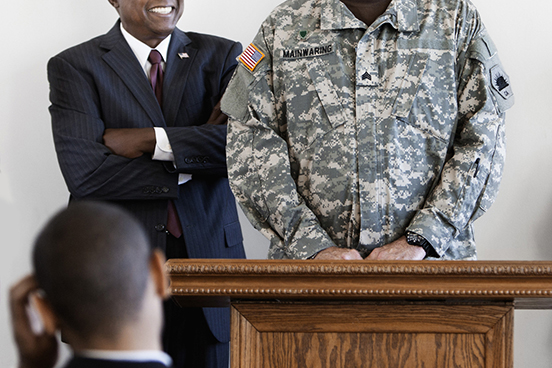 Man in army uniform standing at a podium next another service member talking about va eBenefits.