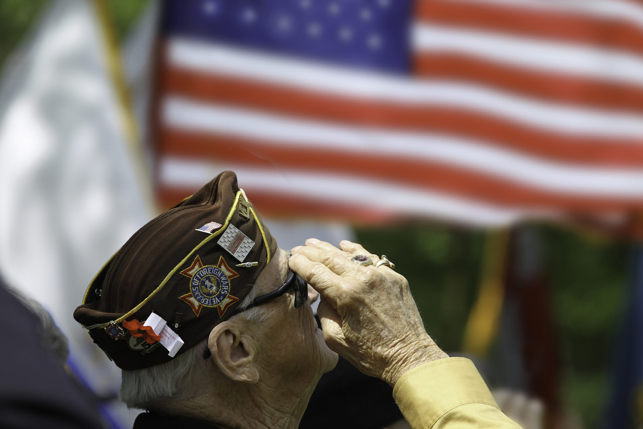 Elderly male veteran saluting American flag