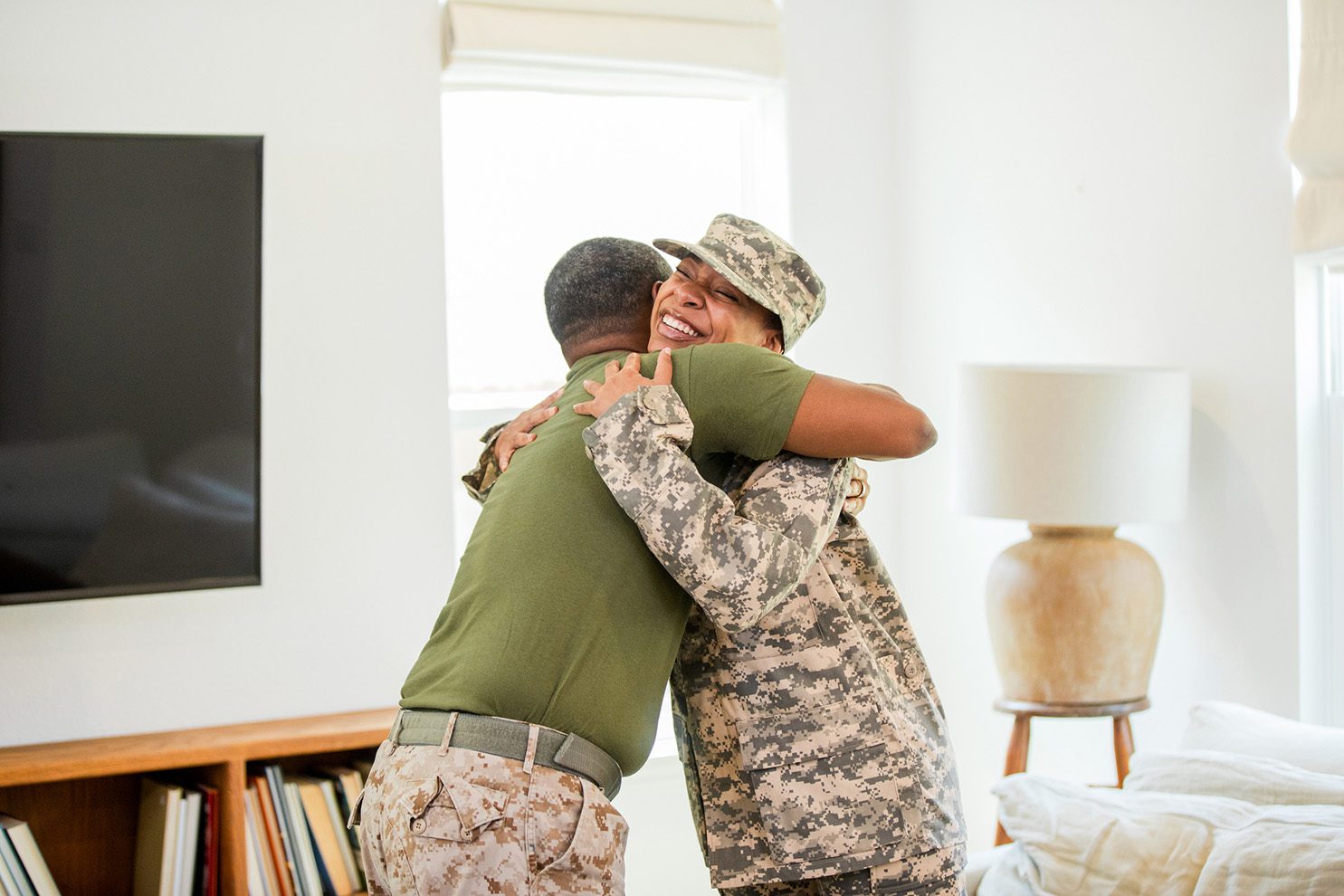 Arriving home safely from her deployment, the proud father hugs his military daughter.