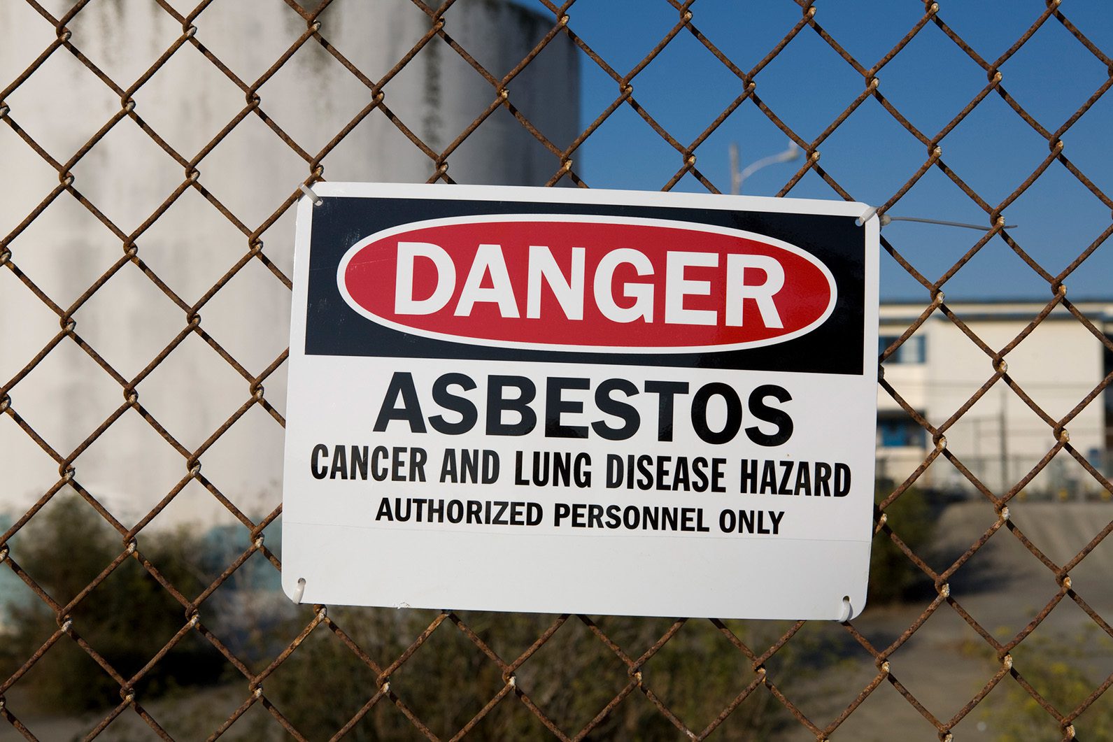 Sign on chain link face saying "Danger. Asbestos."